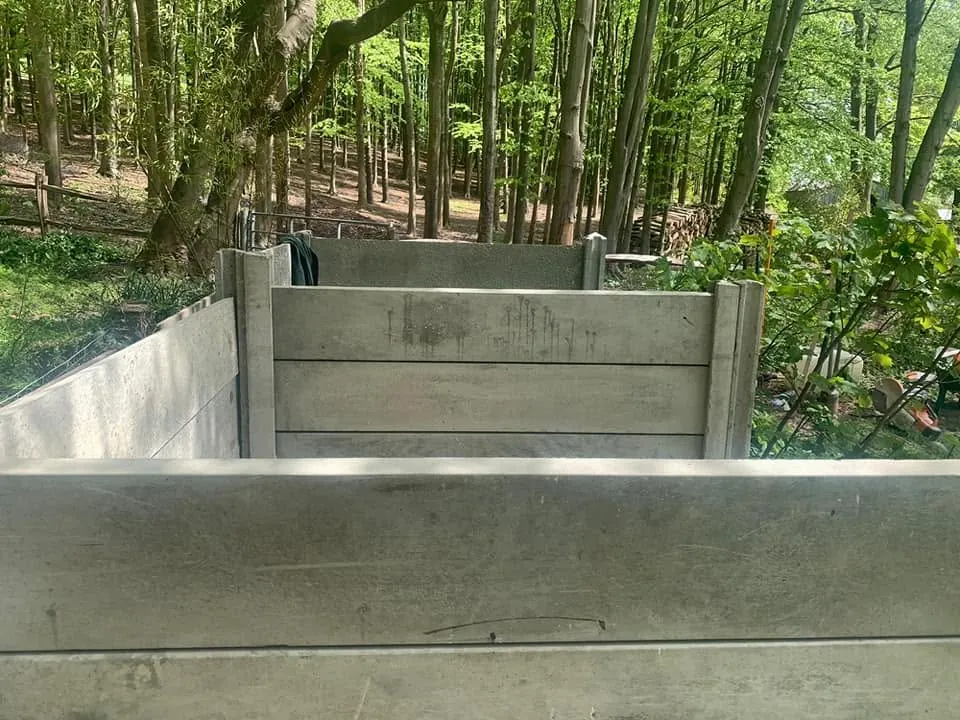 Concrete compost bins seen from above, with gravel boards fitted between concrete posts