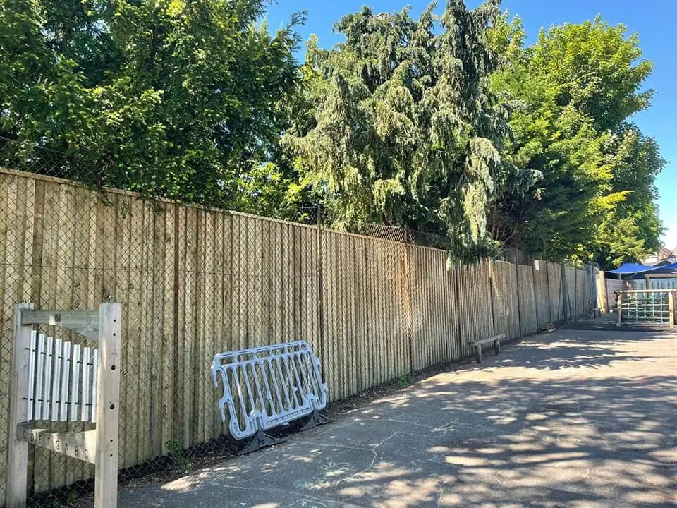 Tall timber acoustic fence along a school playground, fitted by Tyrrells