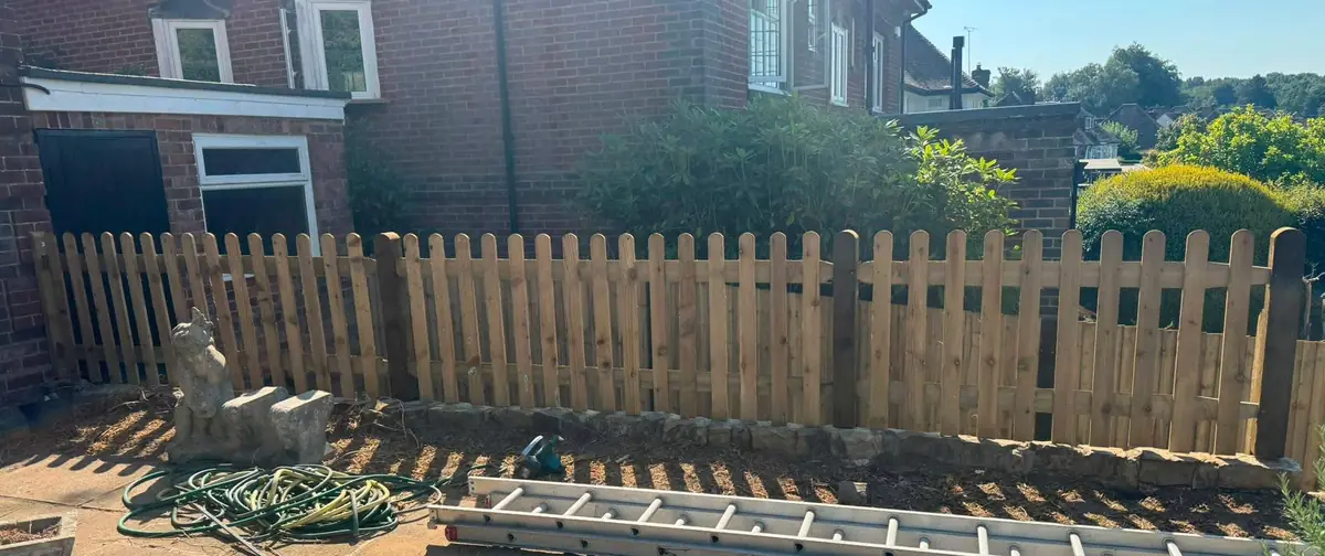 Round-top timber palisade fence along a front garden, fitted by Tyrrells