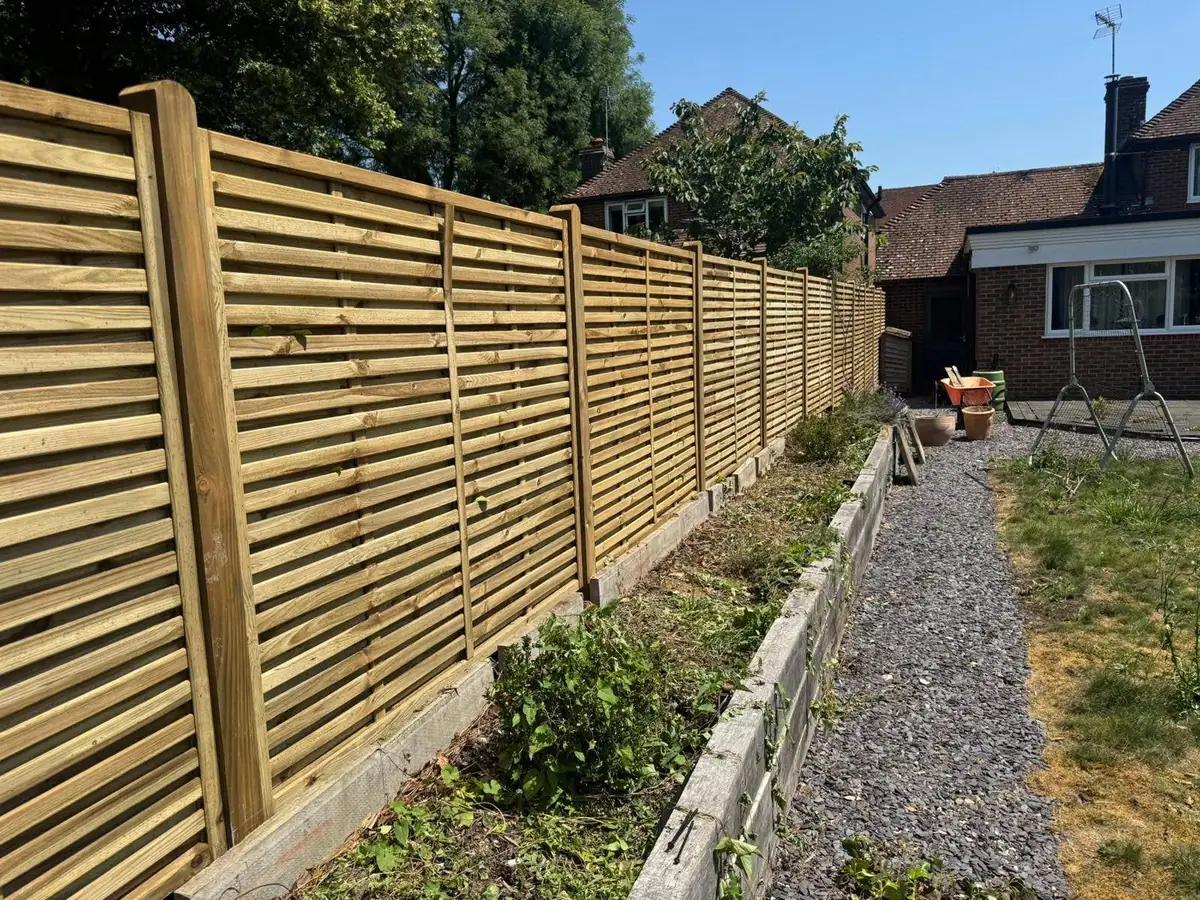 Venetian slatted fence panels along a raised border, fitted by Tyrrells